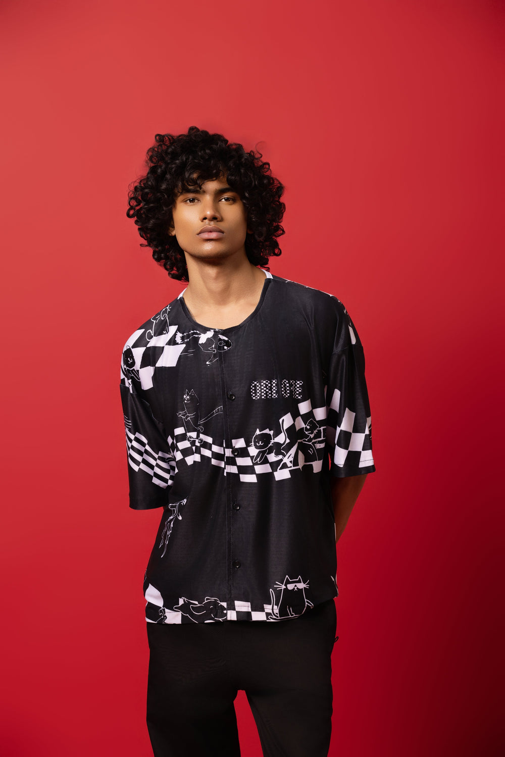 Model wearing an oversized shirt inspired by baseball jerseys, featuring a bold racing mania design print