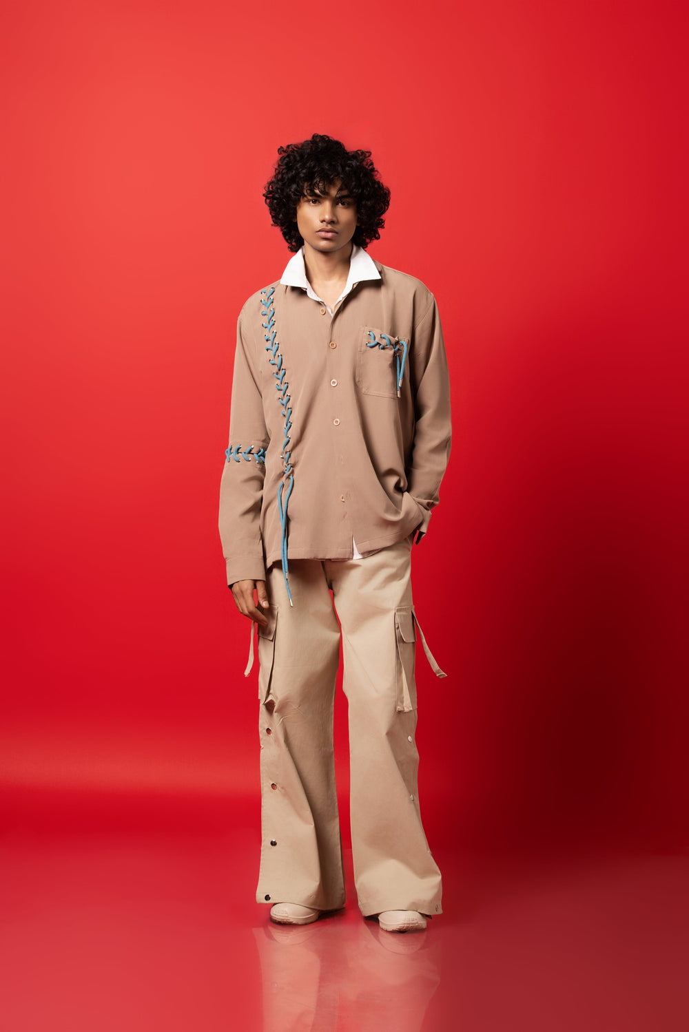 Male Model wearing a bold, edgy beige dropped shoulder shirt made from Banana Crepe fabric.