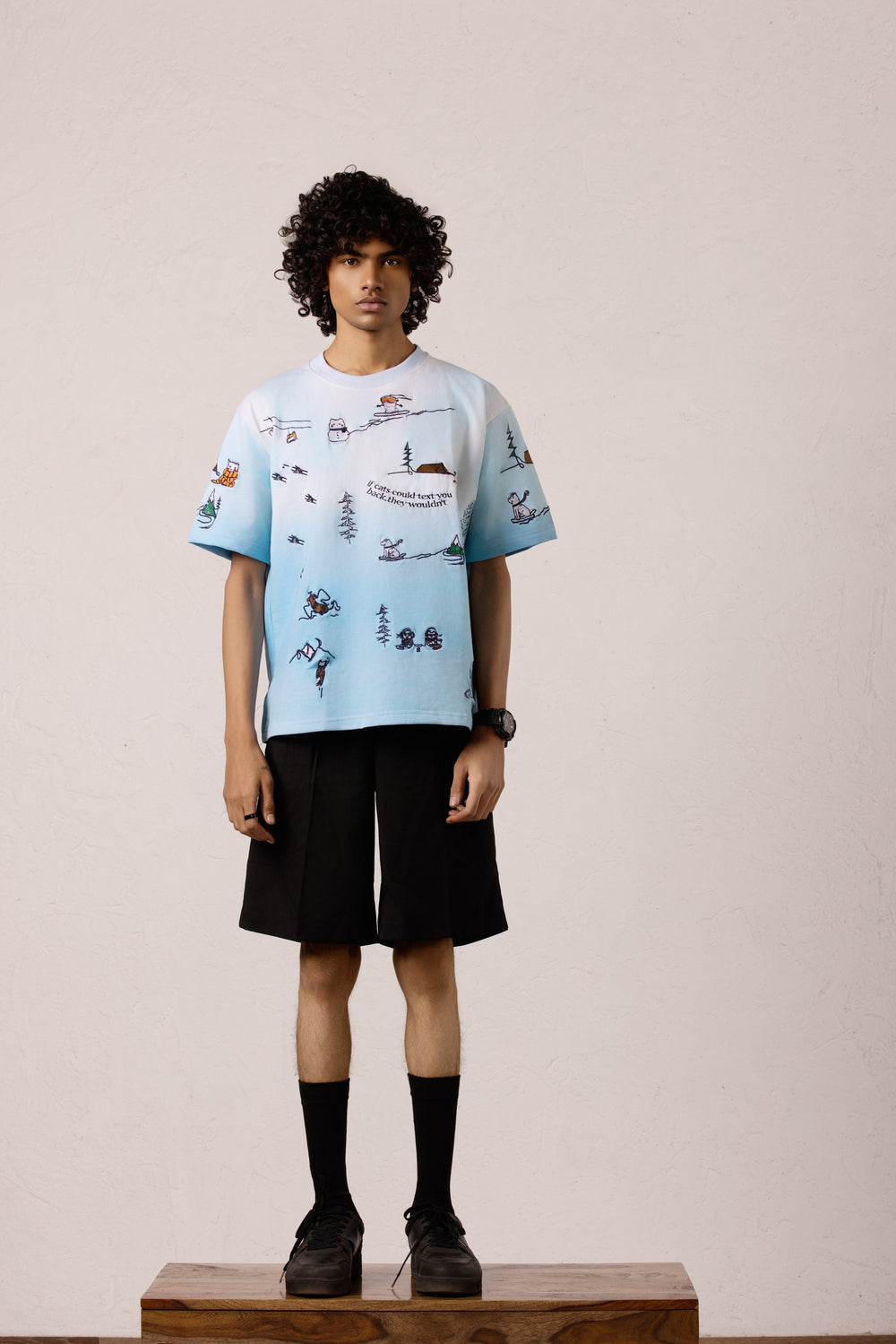 Model wearing the Snowy Dreams Oversized T-shirt with black pants, featuring embroidery print.