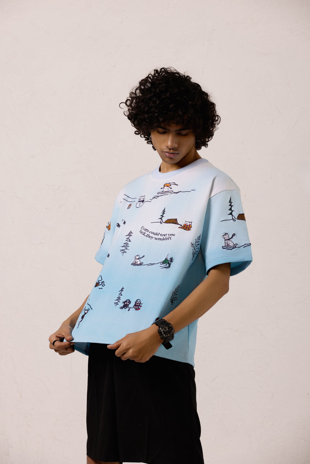 Model wearing the Snowy Dreams Oversized T-shirt with black pants, featuring embroidery print.