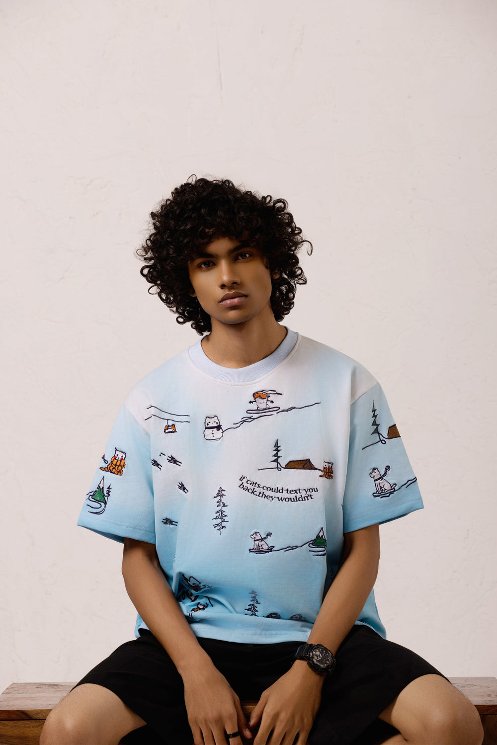 Model wearing the Snowy Dreams Oversized T-shirt with black pants, featuring embroidery print.