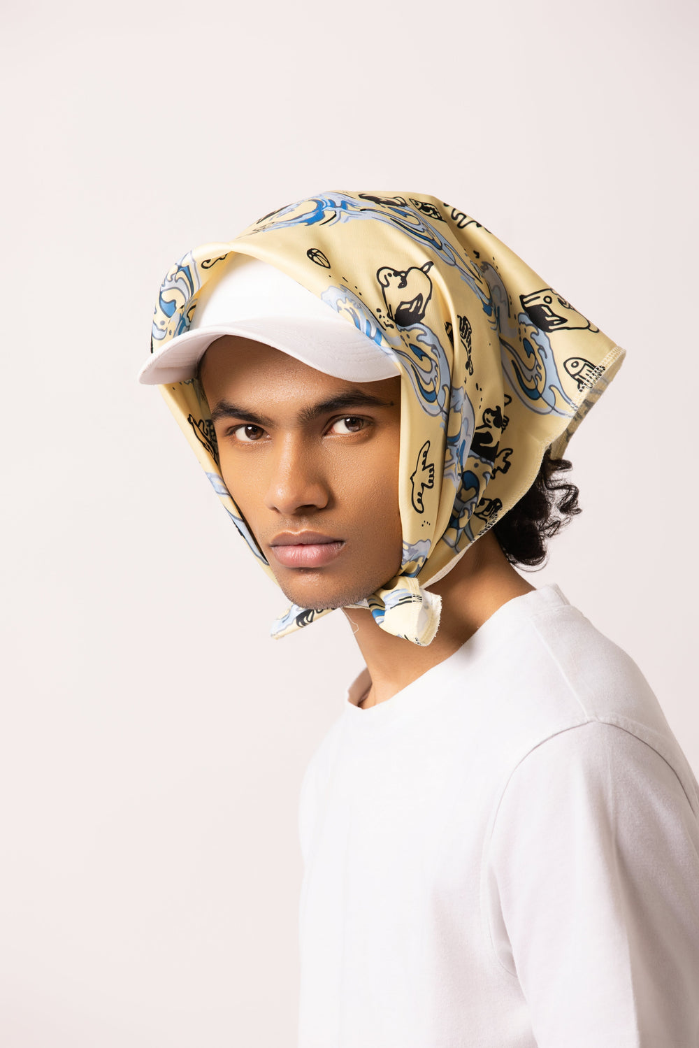 Model wearing the Surf Up Multi-purpose Bandana as a headband, featuring a surfing dog design, made from 100% cotton.