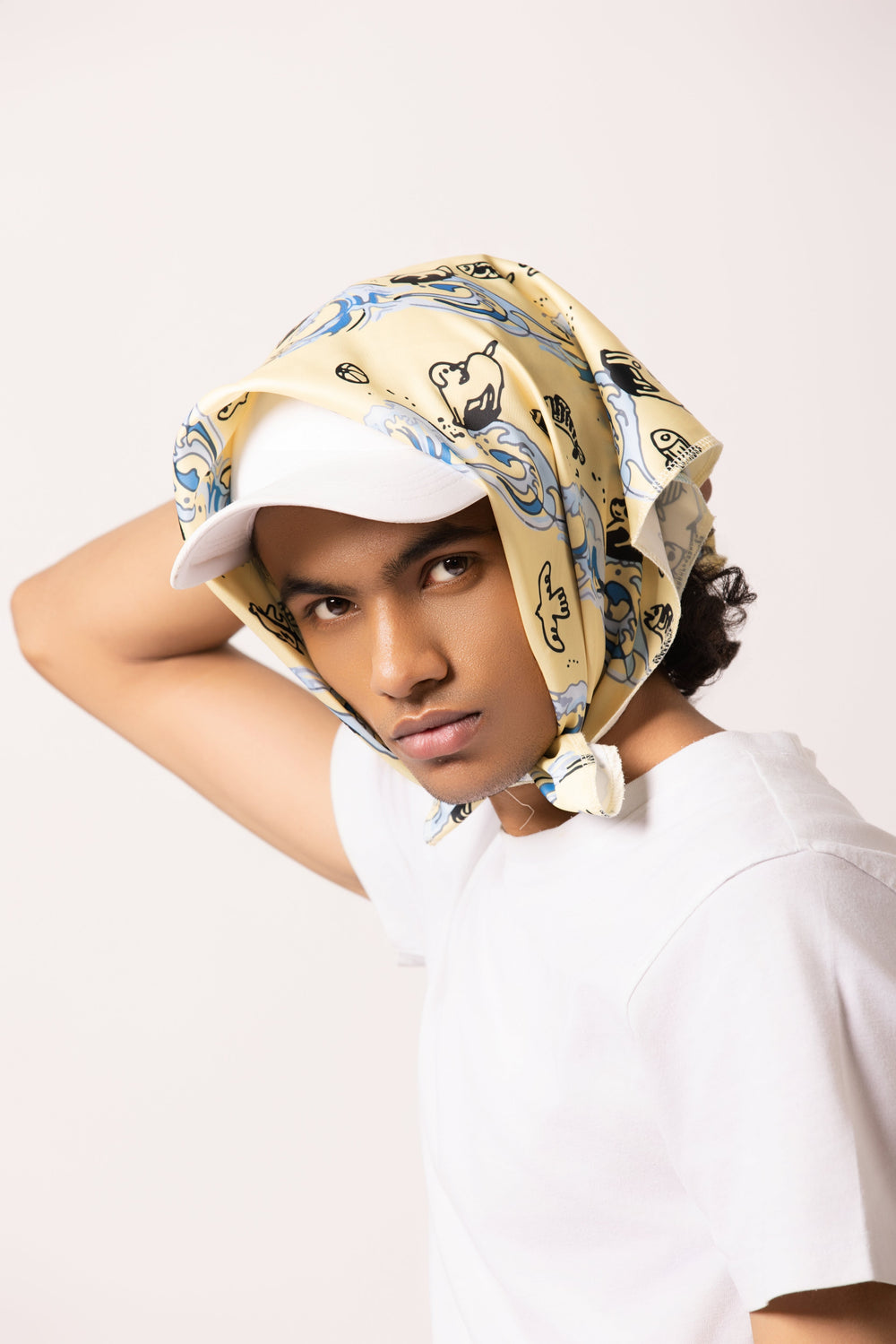 Model wearing the Surf Up Multi-purpose Bandana as a headband, featuring a surfing dog design, made from 100% cotton.